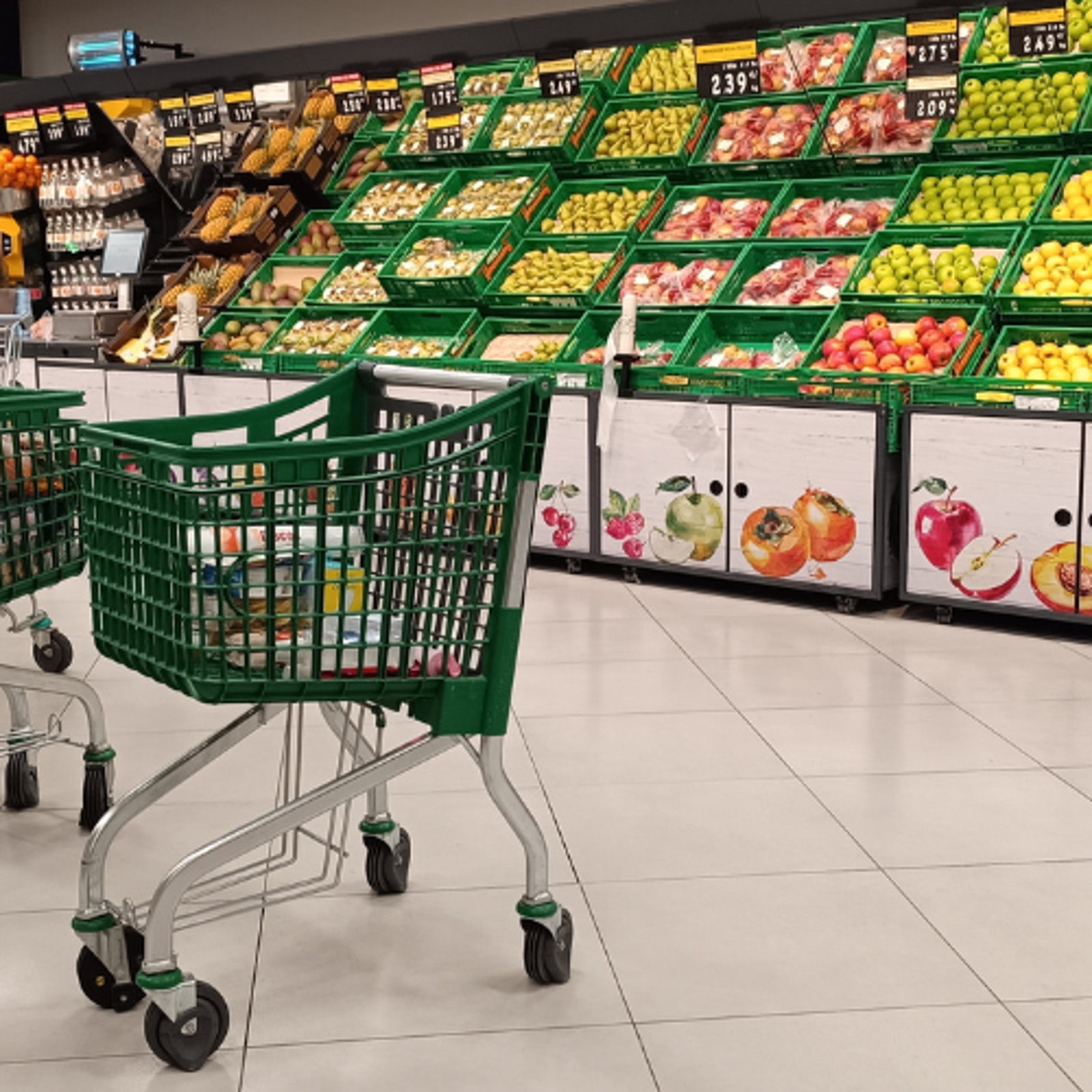 Foto real de la sección de frutería de un Mercadona con carros de compra en primer plano