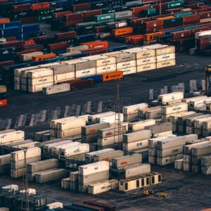 Contenedores apilados en un puerto logístico, símbolo de inventarios y flujos de oferta.