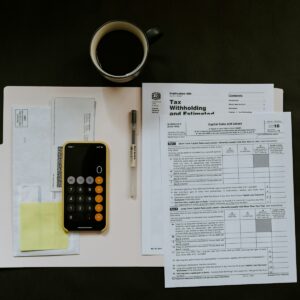 Mesa de trabajo con nominas, calculadora y documentos de empresa