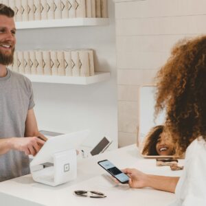 Persona consultando una cuenta bancaria desde un teléfono junto a una tarjeta