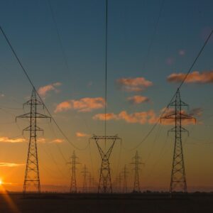 Torres y líneas eléctricas al atardecer, infraestructura energética esencial para la industria europea