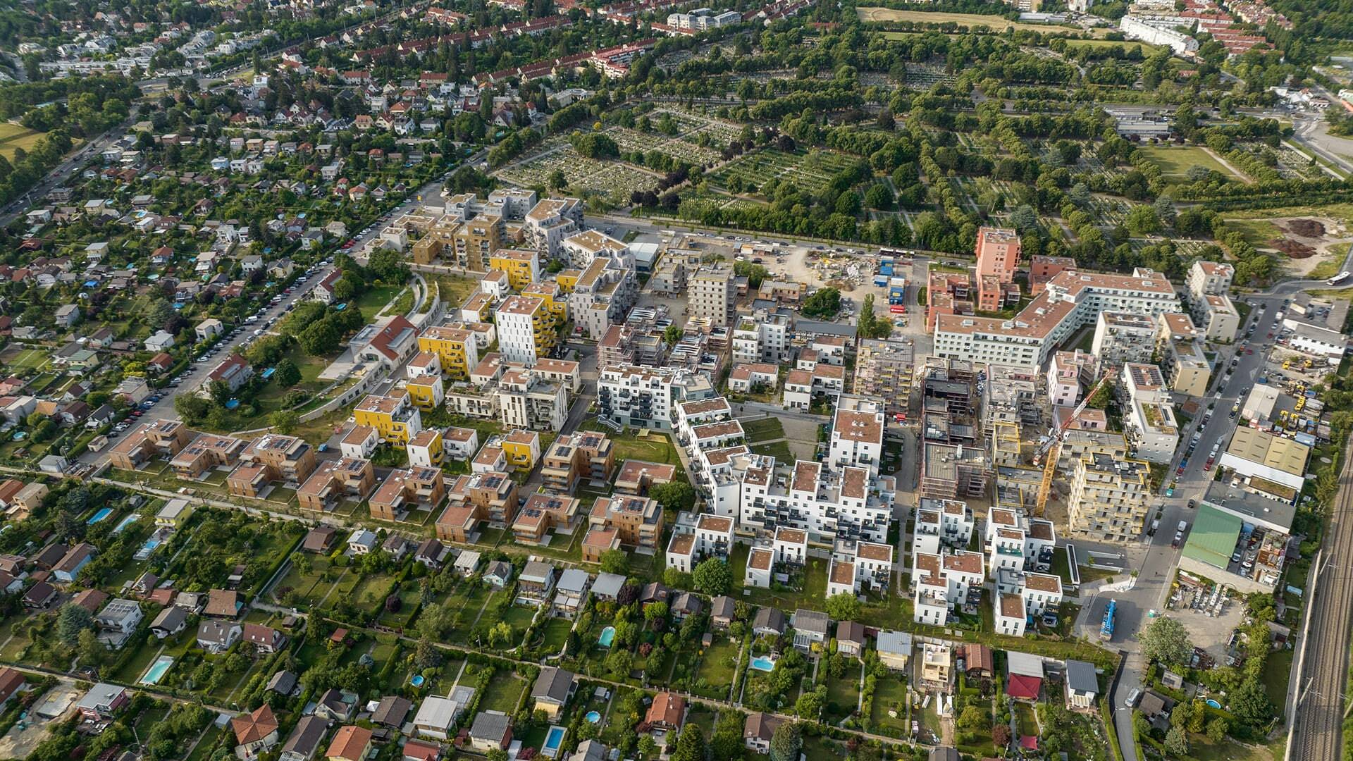 Vista aérea del desarrollo residencial de Wildgarten en Viena, con edificios y zonas de obra